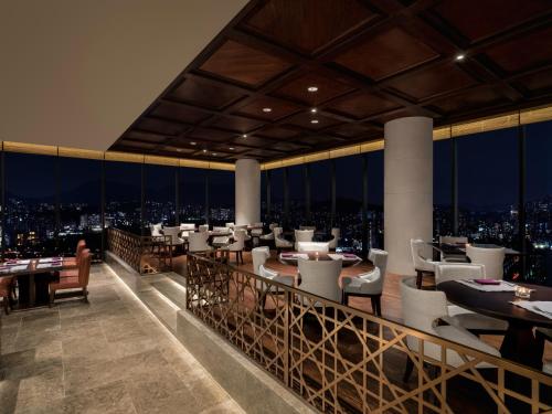 a restaurant with a view of the city at night at Grand Mercure Ambassador Hotel and Residences Seoul Yongsan in Seoul