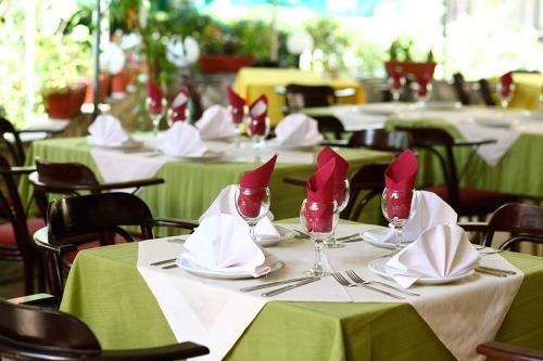 a group of tables with red napkins and wine glasses at Hotel Korzo in Bitola