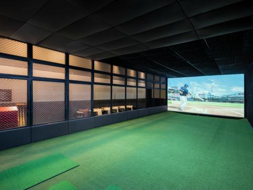 a room with a green floor and a view of a baseball field at Grand Mercure Ambassador Hotel and Residences Seoul Yongsan in Seoul