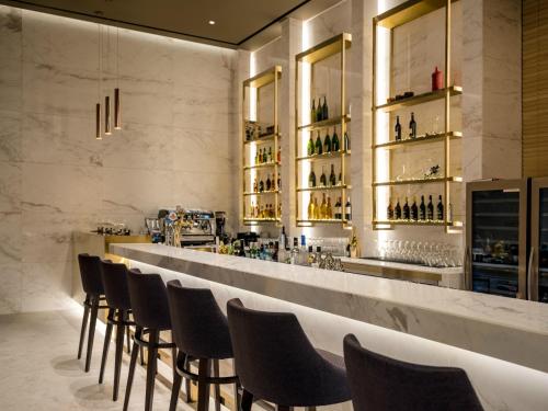 a bar with chairs and a counter with wine bottles at Grand Mercure Ambassador Hotel and Residences Seoul Yongsan in Seoul