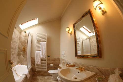 a bathroom with a sink and a toilet and a mirror at Il Sole Di Ranco in Ranco