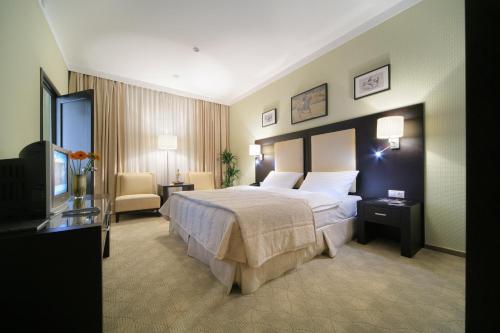 a hotel room with a bed and a television at Business Hotel Senator in Yekaterinburg