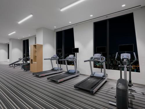 a fitness room with tread machines and windows at ibis Styles Ambassador Seoul Yongsan in Seoul