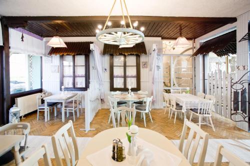 a restaurant with white tables and chairs and a chandelier at Hotel Polski in Mielec