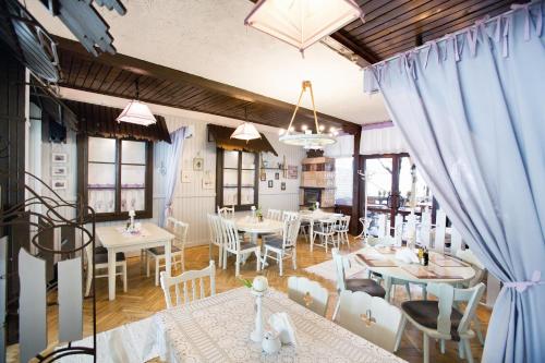 a dining room with tables and chairs and blue curtains at Hotel Polski in Mielec