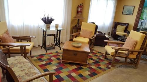 Hotel Cortijo في لاريدو: غرفة معيشة مع كراسي وطاولة قهوة
