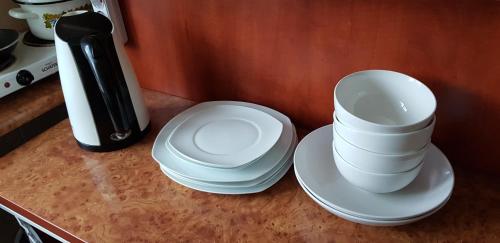 two stacks of white plates sitting on a counter at Apartment Stefan cel Mare 3 in Bălţi
