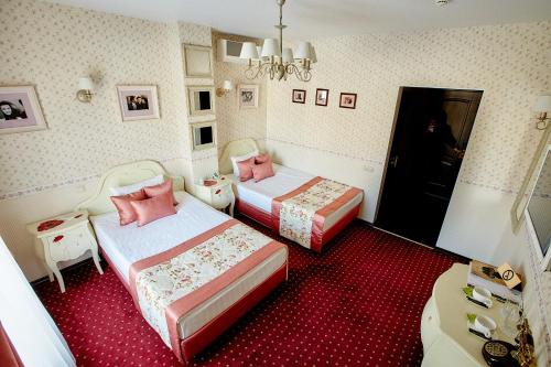 2 camas en una habitación con alfombra roja en O'Hara, en Voronezh