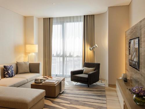 a living room with a couch and a chair at Al Bandar Arjaan by Rotana – Dubai Creek in Dubai