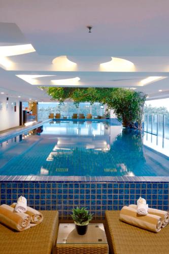 a large swimming pool in a building with a large pool at The Alana Surabaya in Surabaya