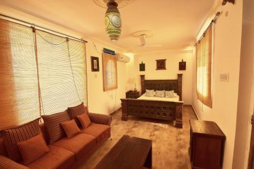 a living room with a couch and a bed at Yogis Guest House in Jodhpur