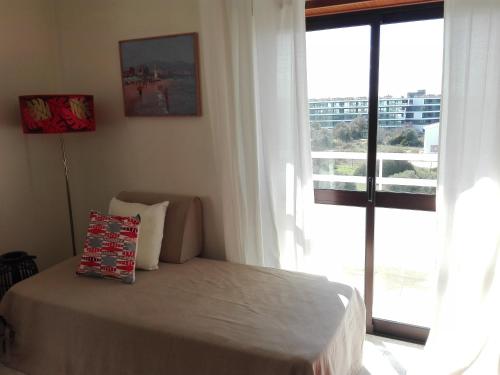a bedroom with a bed and a large window at Apartamento Turf in Alvor