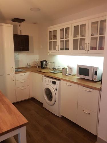 a kitchen with a washing machine and a microwave at Casa Palacio Muñoz Chaves in Cáceres