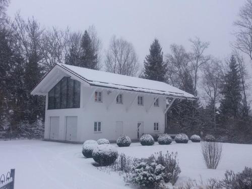 a white house with snow on top of it at Ferienwohnung Schmuckkastl in Tittmoning