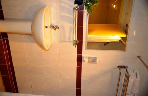 a bathroom with a sink and a mirror at Hotel Caliber in Kuala Lumpur