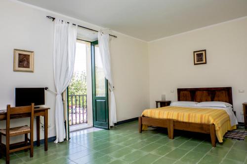 um quarto com uma cama e uma porta de vidro deslizante em Barone GR Macrì Agriturismo Modi em Gerace