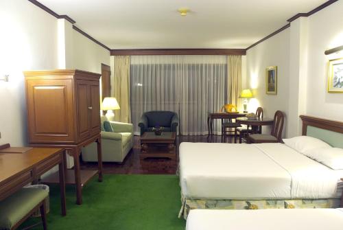 a hotel room with a bed and a desk at Purimas Beach Hotel & Spa in Ban Chang