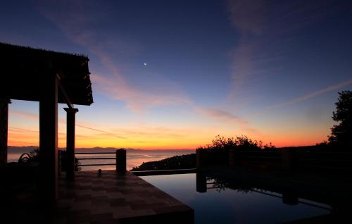 a view of a sunset from a house with a pool at Red Rose Artistsvillas in Gaios