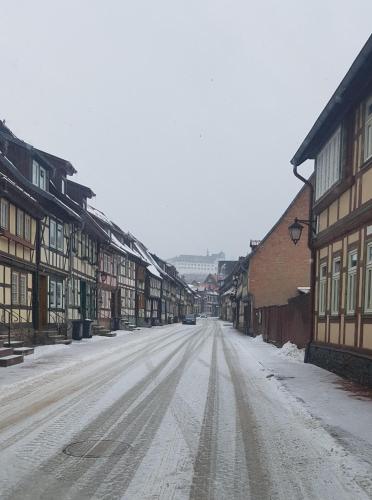 a snow covered street in a town with buildings at Harz Stolberg Ferienwohnung in Stolberg i. Harz