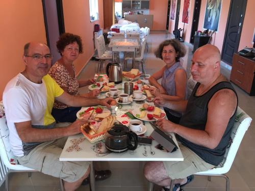 a group of people sitting at a table eating food at Hostel Denisa in Buzau