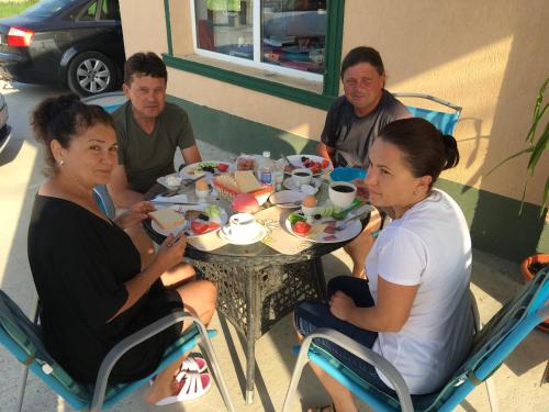 a group of people sitting around a table eating food at Hostel Denisa in Buzau