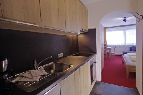 a kitchen with a sink and a living room at Haus Gariella in Gargellen