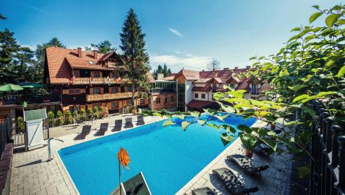 a large swimming pool in front of a house at Hotel Modrzewiówka in Lanckorona