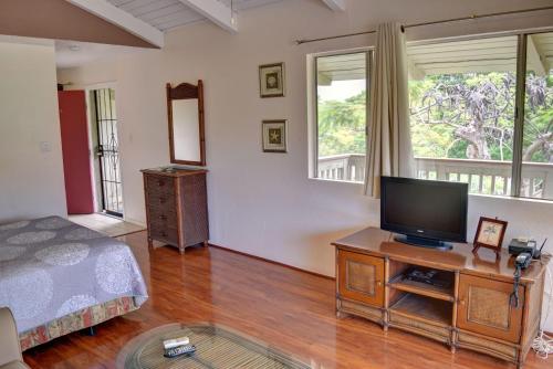 a bedroom with a bed and a television on a table at Kihei Bay Surf 233 in Kihei