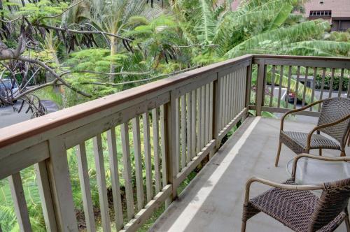 two chairs on a balcony with palm trees at Kihei Bay Surf 233 in Kihei