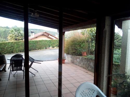 a screened in porch with a view of a patio at Casa Rural Oza dos Ríos in Oza dos Ríos
