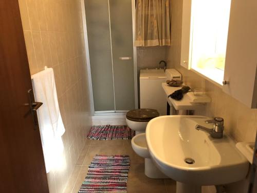 ein Badezimmer mit einem weißen Waschbecken und einem WC in der Unterkunft House Orsa Maggiore by Holiday World in Bordighera
