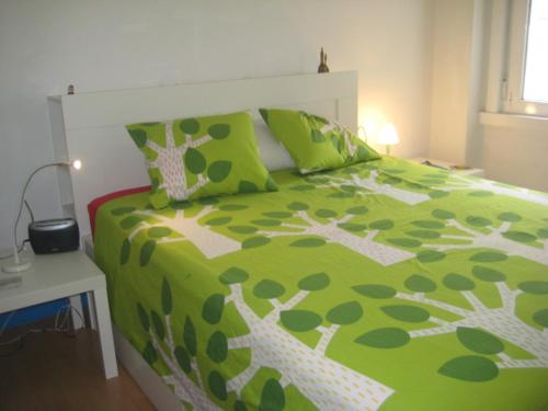 ア・コルーニャにあるPiso en Riazorの緑と白のベッドが備わる客室です。
