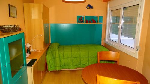 ア・コルーニャにあるPiso en Riazorの小さなベッドルーム(緑のベッド1台、テーブル付)