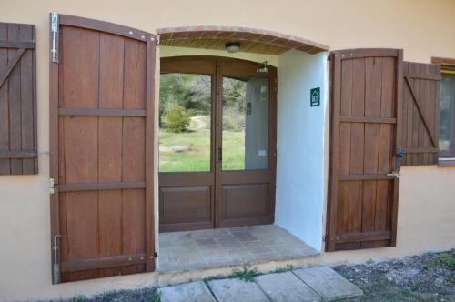 an entrance to a house with wooden doors at Mas Ca La Coixa in Tortellá