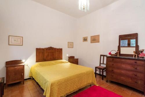 1 dormitorio con cama, tocador y espejo en Ghirindoun, en Celle Ligure