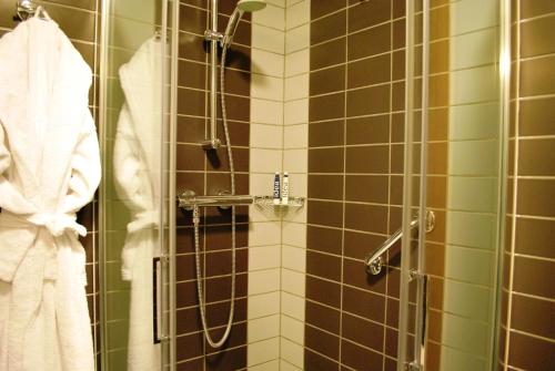 a shower in a bathroom with brown and green tiles at Idea Hotel Plus Savona in Savona