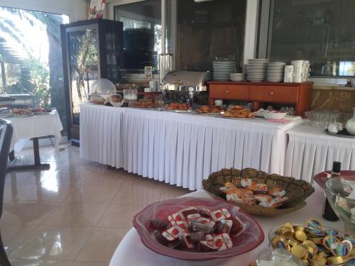 a buffet of food on white tables in a restaurant at Irida Beach Resort Suites in Kyparissia
