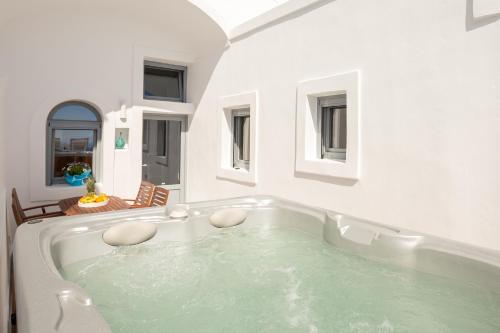 a large white bath tub in a room at Ethereum Luxury Cave in Imerovigli