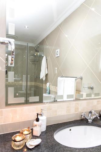 a bathroom with a sink and a shower at Piccolo Villa in St. Helena Bay