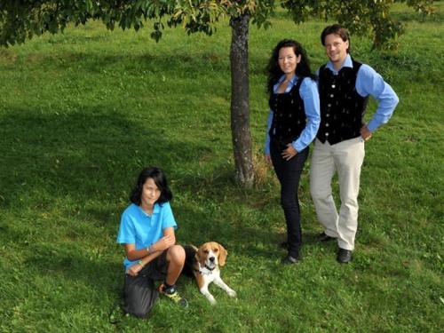 a group of three people and a dog in the grass at Aktiv Hotel Karnia in Hermagor
