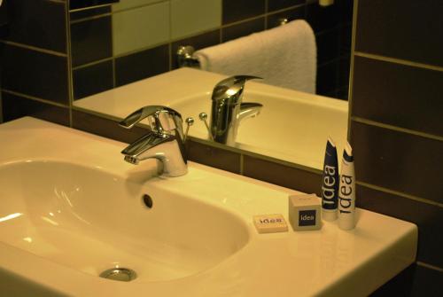 a bathroom sink with a faucet and a mirror at Idea Hotel Plus Savona in Savona