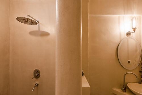 een badkamer met een douche, een wastafel en een spiegel bij Rhapsody house in Nea Vrasna