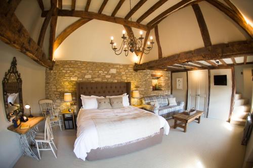 um quarto com uma cama grande e um sofá em The Porch House em Stow on the Wold