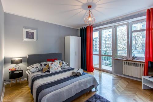 a bedroom with a bed and a large window at ClickTheFlat Żurawia Street Apart Rooms in Warsaw