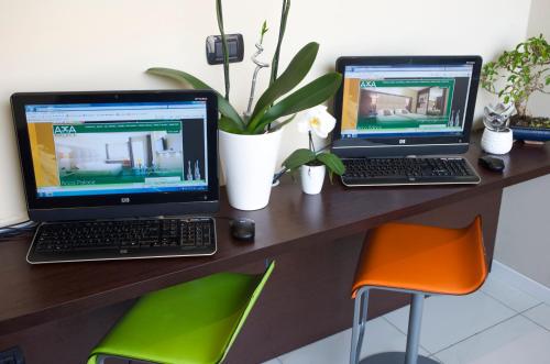 two laptops sitting on a wooden desk with chairs at Acca Palace AA Hotels in Milan