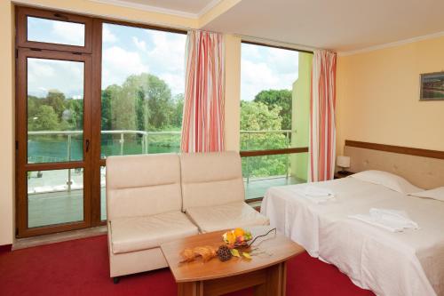 um quarto de hotel com uma cama e uma cadeira e uma janela em Perla Sun Beach Hotel - All Inclusive em Primorsko
