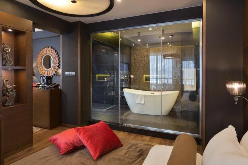 a bathroom with a tub and a large glass window at Family Hotel Strannopriemnitza in Oreshak