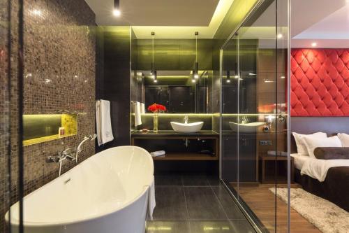a bathroom with two sinks and a bath tub at Family Hotel Strannopriemnitza in Oreshak