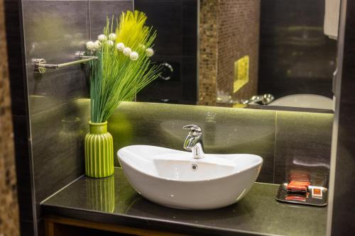 a bathroom with a sink and a vase of flowers at Family Hotel Strannopriemnitza in Oreshak