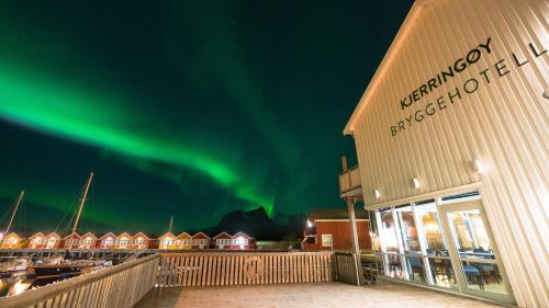 a building with the aurora in the sky over a marina at Kjerringøy Bryggehotell in Bodø